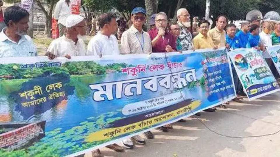মাদারীপুরে শকুনি লেক রক্ষায় পাড়ে সমবেত হয়ে মানববন্ধন করছেন সচেতন নাগরিক ও বিভিন্ন সংগঠনের প্রতিনিধিরা